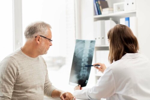 Læge taler med mandlig patient om røntgen af ryg