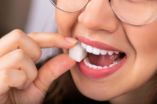 Kvinde bider i sukkerknald for at demonstrere forholdet mellem diabetes og tandsundhed