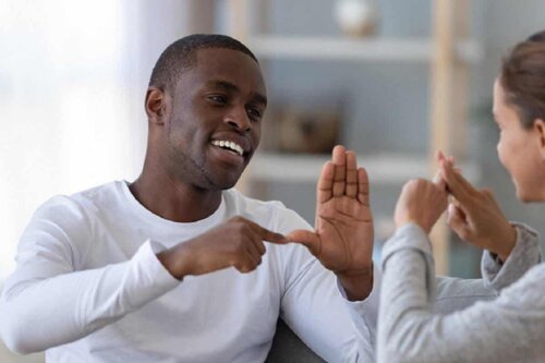 Barn og voksen taler sammen ved at bruge tegnsprog