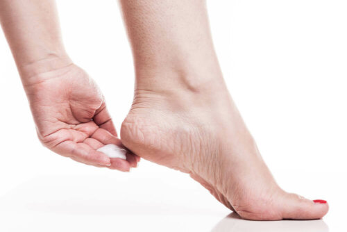 Kvinde kommer creme på fødder for at fremme fodsundhed