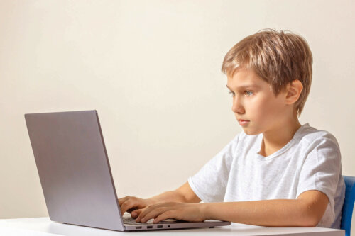 Dreng ved computer er i gang med onlineundervisning