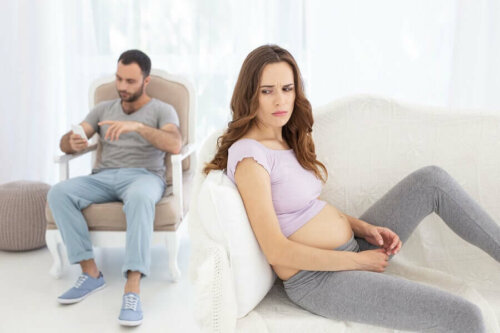 Frustreret gravid kvinde med mand i baggrunden