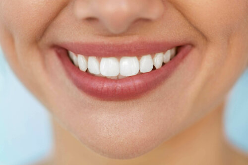 Kvinde smiler og viser, hvad tænder er lavet af