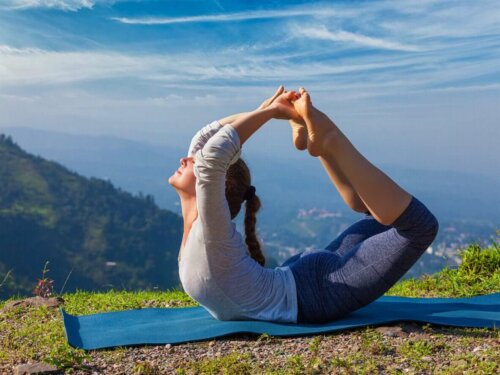 Kvinde dyrker yoga med udsigt over bjerg