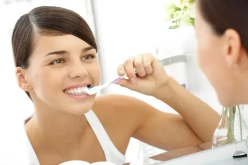 Kvinde er ved at børste tænder