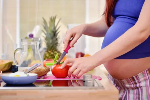 Gravid kvinde laver mad