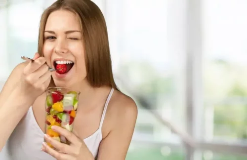 Kvinde med frugt er eksempel på at spise mellem måltiderne