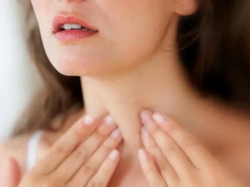 Kvinde tager sig til hals og oplever en sygdom, der forårsager kuldefornemmelser