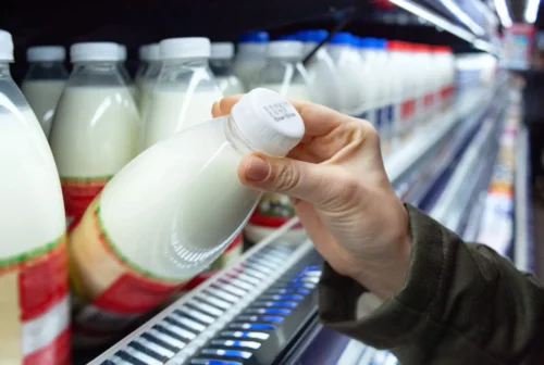 Person tager mælk i supermarked
