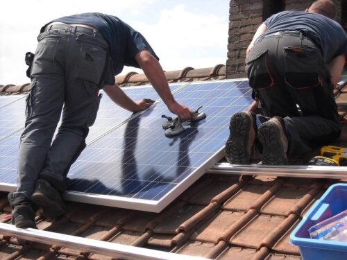 To mænd er ved at rengøre solpaneler