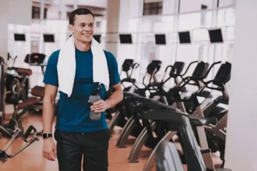 Mand i fitnesscenter prøver at omdanne fedt til muskler