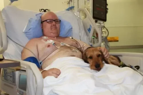 Mand med hund viser, hvordan kæledyr besøger patienter