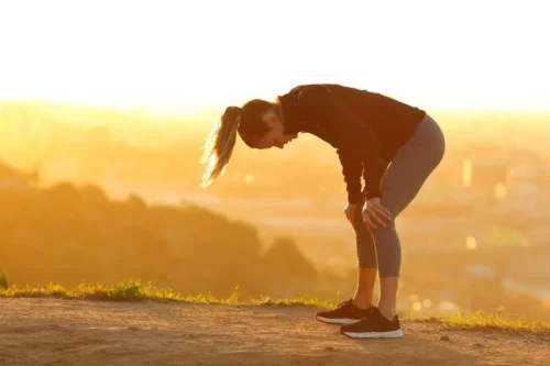 Kvinde holder pause på løbetur, da hun har valgt at træne under sygdom
