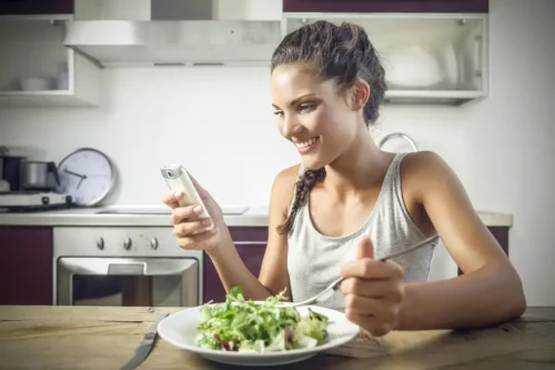 Kvinde med salat ser på kostvideoer på TikTok