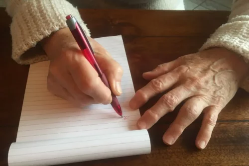 Person skriver i hånden