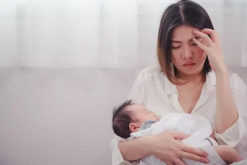 Træt mor med baby i armene