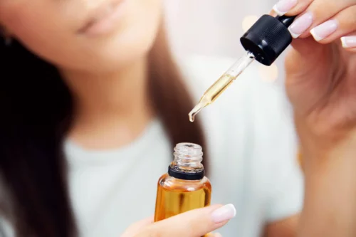 Kvinde tager æterisk olie med pipette, men hvad er æteriske olier egentlig?