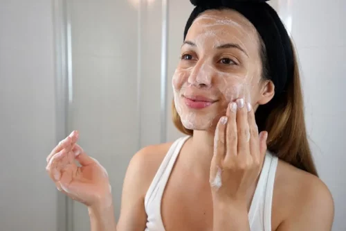 Kvinde bruger scrub med Centella asiatica i ansigtet
