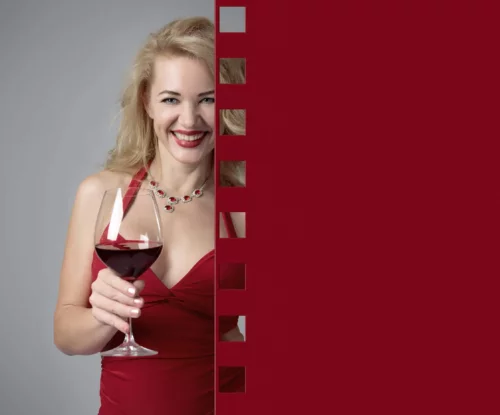 Smilende kvinde med rødvin i hånden