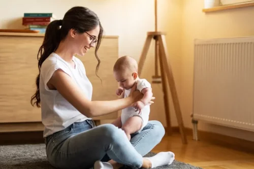 Mor hjælper baby med at lære at sidde selv