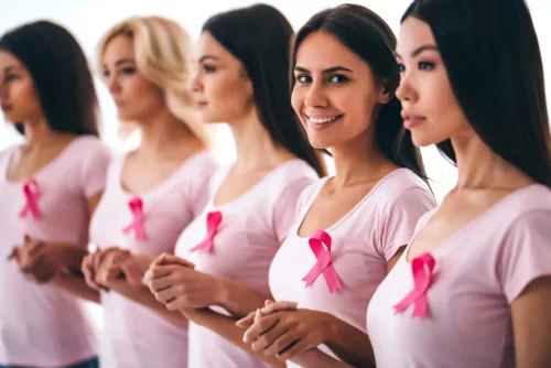 Kvinder med lyserøde sløjfer, der repræsenterer brystkræft