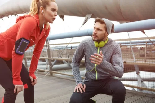 Kvinde modtager tale fra mand under løb til at forbedre sportspræstationer