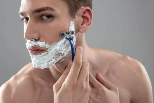 En mand barberer sig