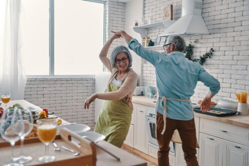 Par nyder at danse i køkkenet, mens de laver mad