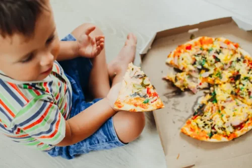 Barn med pizza repræsenterer fødevareørkener