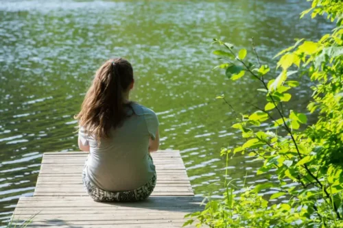 Kvinde, der sidder alene og ser på vand, symboliserer Honjok