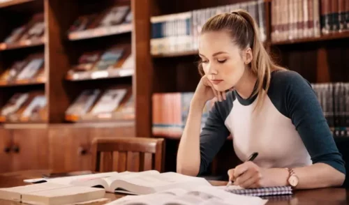 Kvinde på bibliotek illustrerer at studere med ADHD