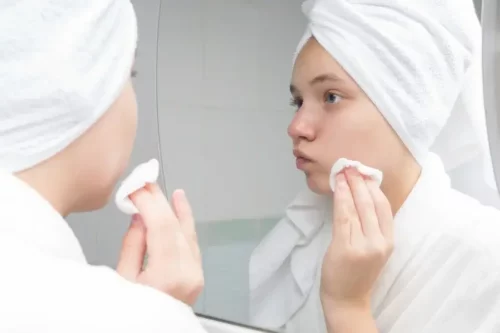 Ung kvinde renser sin hud