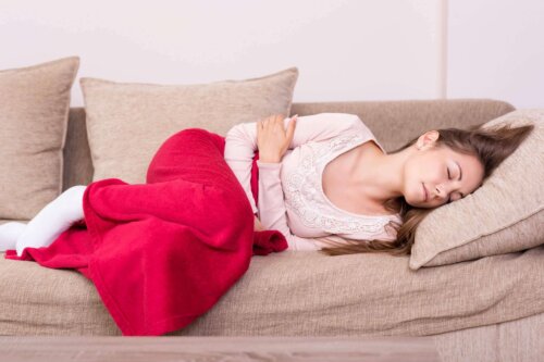 Kvinde på sofa oplever menstruationstræthed