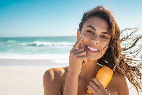 Kvinde påfører solcreme for at forebygge hyperpigmentering
