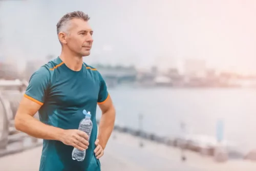 Mand drikker vand efter udendørs motion