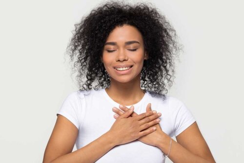 Smilende kvinde med lukkede øjne tænker på taknemmelighedsbekræftelser