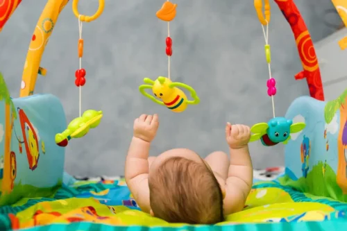 Baby på aktivitetstæppe repræsenterer børns absorberende sind