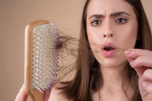 Kvinde fjerner løse hår fra børsten