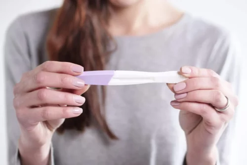 Kvinde står med graviditetstest