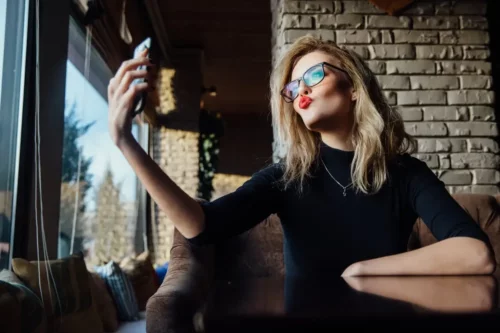 Kvinde tager selfie og laver kysmund
