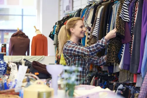 Kvinde ser på tøj i butik og viser, at mange køber mere under udsalg