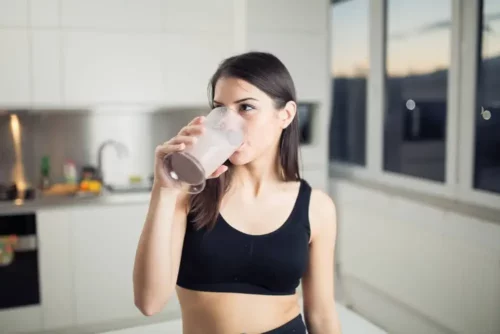 Kvinde drikker en proteinshake