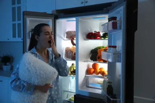 Kvinde åbner køleskab om natten