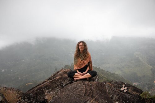 Kvinde mediterer på bjergtop