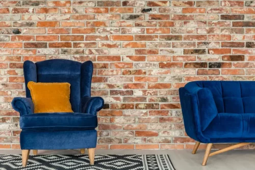 Stue med blå møbler og en sennepsgul pude