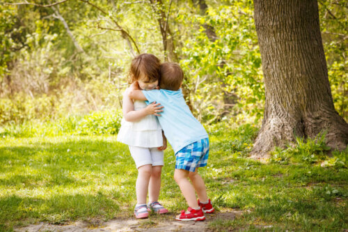 To børn krammer i skov