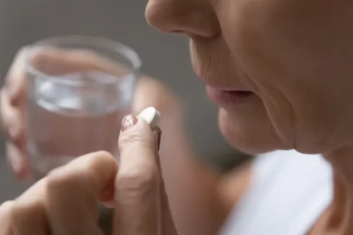 Kvinde tager pille som en del af daglig brug af aspirin