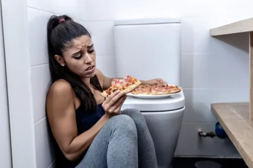 Kvinde med pizza på toilet oplever skyldfølelse over at spise