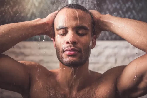 Mand tager et brusebad som en del af hudpleje med diabetes
