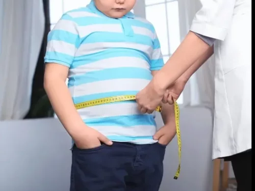 En overvægtig dreng måles af en læge